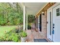 Inviting front porch with brick flooring and a rocking chair, surrounded by lush landscaping at 4845 Dartford Dr, Powder Springs, GA 30127