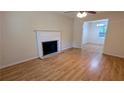 Bright living room with hardwood floors, a fireplace, ceiling fan, and a view into the dining area at 4927 Millstone Walk, Stone Mountain, GA 30088