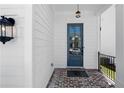 Inviting entryway with brick flooring, decorative light fixture, and blue front door at 627 Skytop Dr, Cumming, GA 30040