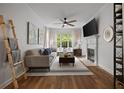 Bright living room features a ceiling fan, fireplace, and large windows with natural light at 123 Ashford Cir, Atlanta, GA 30338