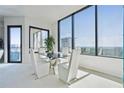 Bright dining room with floor to ceiling windows providing skyline views and a modern glass dining table at 2828 Peachtree Nw Rd # 2002, Atlanta, GA 30305