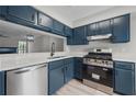 Modern kitchen featuring blue cabinets, stainless steel appliances, and light countertops at 3072 Revere Ct, Atlanta, GA 30340