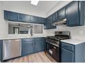 Modern kitchen featuring blue cabinets, stainless steel appliances, and light countertops at 3072 Revere Ct, Atlanta, GA 30340