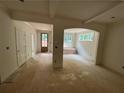 Living room featuring unfinished flooring, arched doorways, and multiple windows at 4110 Post Gate Ct, Cumming, GA 30040