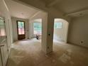Living room with a view from the interior of windows looking to the yard and unfinished flooring at 4110 Post Gate Ct, Cumming, GA 30040