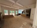 Unfinished living room featuring coffered ceilings and a view into the kitchen at 4110 Post Gate Ct, Cumming, GA 30040