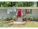 Welcoming home featuring a striking red front door and manicured shrubs along the front entrance at 200 Robin Hood Ln, Hampton, GA 30228