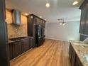 Modern kitchen with sleek, dark cabinets, stainless steel appliances, and light wood-look flooring at 610 Coolsprings Ln, Woodstock, GA 30188