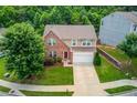 An aerial shot of a well-maintained two-story home with a neatly landscaped lawn in a lush, green neighborhood at 1727 Shire Village Dr, Sugar Hill, GA 30518