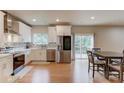 Modern kitchen with white cabinetry, stainless steel appliances, and a view to the deck and backyard at 1727 Shire Village Dr, Sugar Hill, GA 30518