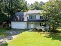 Two-story home with attached garage, complemented by a well-maintained lawn and mature trees, creating a welcoming curb appeal at 5427 Highway 81, Loganville, GA 30052