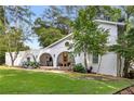 Charming white home with arched porch, balcony, and mature trees in a serene setting at 5714 Braddock Ct, Atlanta, GA 30350