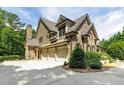 Spacious three car garage complements this home's side elevation and landscaped yard at 930 Shepards Ct, Roswell, GA 30075