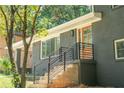 Elegant entrance featuring a wood door, dark gray brick, and black railings at 2524 Glenrock Dr, Decatur, GA 30032