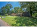 Well-maintained front yard with mature trees surrounding a one-story brick home at 2524 Glenrock Dr, Decatur, GA 30032