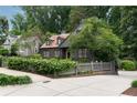 A charming house with well-maintained landscaping, mature trees, and a paved driveway at 1860 Anjaco Nw Rd, Atlanta, GA 30309