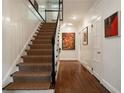 Hallway and staircase featuring hardwood floors, carpeted stairs, and white paneled walls at 1860 Anjaco Nw Rd, Atlanta, GA 30309