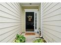 A welcoming front entrance featuring a black door, seasonal wreath, and decorative plants at 125 Flatwood Trail, Marietta, GA 30066