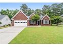 Charming brick home with a well-manicured lawn, attached garage, and inviting front entrance at 192 Sandhurst Ct, Suwanee, GA 30024
