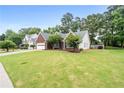 Spacious front yard showcasing a brick home with an attached garage and manicured landscaping at 192 Sandhurst Ct, Suwanee, GA 30024
