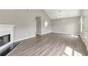 Open living room with wood-look floors, fireplace, and access to other areas of the home at 2022 Patterson Park Dr, Lawrenceville, GA 30044