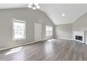 Bright living room with vaulted ceiling, fireplace, and modern gray wood-look flooring at 2022 Patterson Park Dr, Lawrenceville, GA 30044