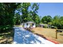 Inviting home showcasing a lengthy driveway, complemented by lush landscaping and a charming yellow front door at 4244 Lindsey Dr, Decatur, GA 30035