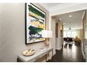 Stylish home entryway showcases a console table with décor, eye-catching wall art and hardwood floors at 4327 Azalea Ridge Way, Hoschton, GA 30548