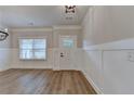 Inviting entryway with a classic paneled door, stylish wainscoting, and durable wood-look floors at 2090 Harvester Ln, Buford, GA 30518