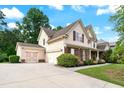 Side view of a home with a three-car garage and a well-maintained lawn on a sunny day at 1626 Waterchase Dr, Dacula, GA 30019