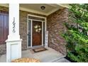 Inviting front entrance with a stone facade, decorative wreath, and well-manicured landscaping at 1626 Waterchase Dr, Dacula, GA 30019