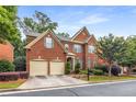 Attractive brick two-story home featuring an attached two-car garage, landscaped yard, and inviting entryway at 2132 Wrights Mill Ne Cir, Atlanta, GA 30324