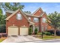 Classic brick two-story home with a two-car garage and nicely landscaped front yard with seasonal color at 2132 Wrights Mill Ne Cir, Atlanta, GA 30324
