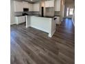 Open kitchen with white cabinetry, black countertops, island and modern appliances at 3867 Lockaby Way, Lawrenceville, GA 30044