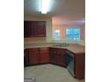 The kitchen has brown cabinets, stone countertops, and stainless steel appliances at 6398 Shadow Sq, Lithonia, GA 30058