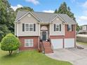 Two-story home featuring a brick and siding exterior, two-car garage, and landscaped front yard at 173 Cline Smith Ne Rd, Cartersville, GA 30121