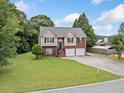 Exterior shot of a charming two-story home on a well-maintained lot with mature trees at 173 Cline Smith Ne Rd, Cartersville, GA 30121