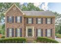 Stately brick home featuring classic shutters, a manicured lawn, and a welcoming entrance for timeless appeal at 2056 Plantation Rd, Lawrenceville, GA 30044