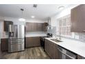 Modern kitchen with stainless steel appliances, grey cabinets, and a stylish backsplash at 2279 Hickory Grove Nw Rd, Acworth, GA 30101