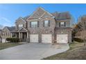 Charming two-story brick home featuring a three-car garage and meticulously manicured lawn at 7691 Brazos Trl, Fairburn, GA 30213