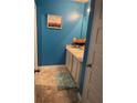 Bright bathroom featuring a double sink vanity, blue walls, and a decorative sunflowers picture for a cheerful ambiance at 11547 Hathaway Dr, Hampton, GA 30228