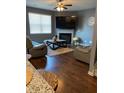 Cozy living room with hardwood floors, a fireplace, neutral furnishings, and a large screen TV, perfect for relaxation at 11547 Hathaway Dr, Hampton, GA 30228