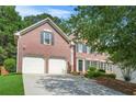 Exterior view of a beautiful brick two-story home featuring an attached two-car garage and front landscaping at 3059 Brookgreen Trl, Lawrenceville, GA 30043