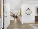 Bright foyer with wood floors, a decorative mirror, and artwork, leading into the home's living spaces at 4317 Azalea Ridge Way, Hoschton, GA 30548