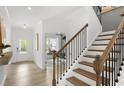 Elegant staircase with wood treads and black iron balusters, adjacent to a light-filled office space at 4317 Azalea Ridge Way, Hoschton, GA 30548