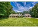 Charming home with a well-manicured lawn, stone accents, and a matching garage building at 2680 Bay Ridge Dr, Loganville, GA 30052
