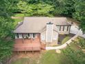 Aerial view showcasing a cozy home with a large wooden deck surrounded by trees at 3329 Walt Stephens Rd, Stockbridge, GA 30281
