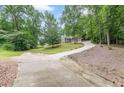 View of a long concrete driveway leading to a cozy home on a grassy lot at 3329 Walt Stephens Rd, Stockbridge, GA 30281