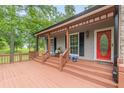 Inviting front porch with a seating area and a red door that adds a pop of color at 3329 Walt Stephens Rd, Stockbridge, GA 30281