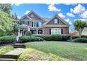 Beautiful two-story brick home with a manicured lawn and a welcoming front porch with beautiful bushes at 4770 Spring Park Cir, Suwanee, GA 30024